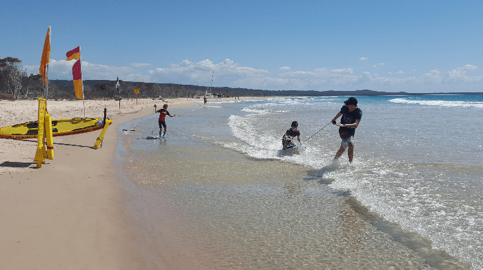 Image of a few kids playing in the shallow water  on a beach having fun in the shallow water