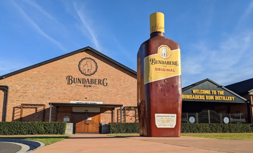 Large bottle of Bundaberg Rum outside the building with sign saying Bundaberg Rum Distillery