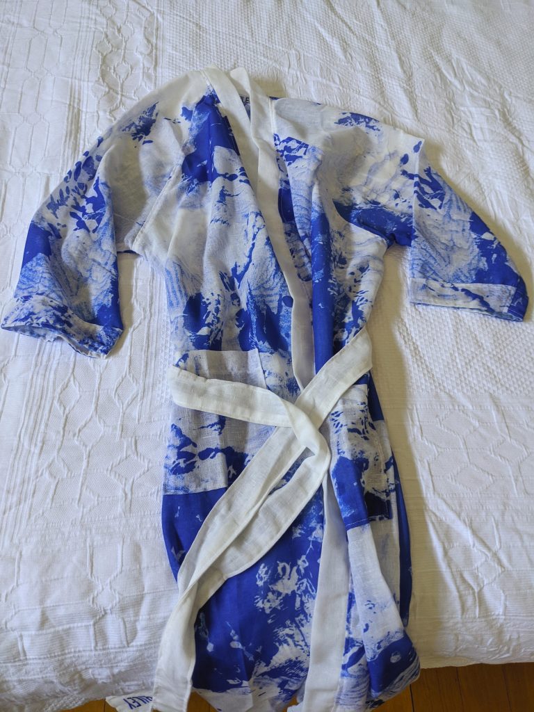 Blue and white kimino style gown on a white bedspread