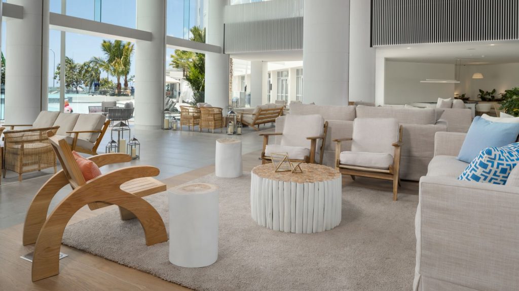 Two white chairs and small table in a open plan hotel lobby