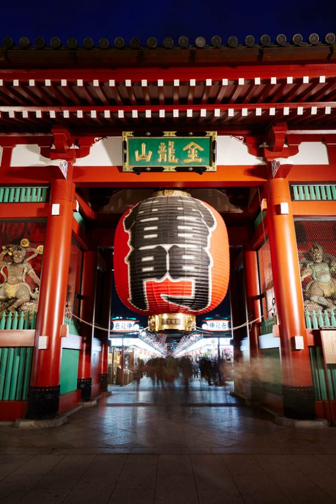 Image of a red gate with a large lantern hangin in the middle