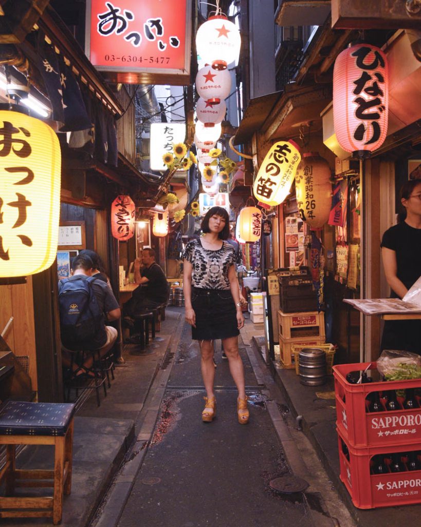 Image of a Japanese woman standing in a alleyway in Tokyo