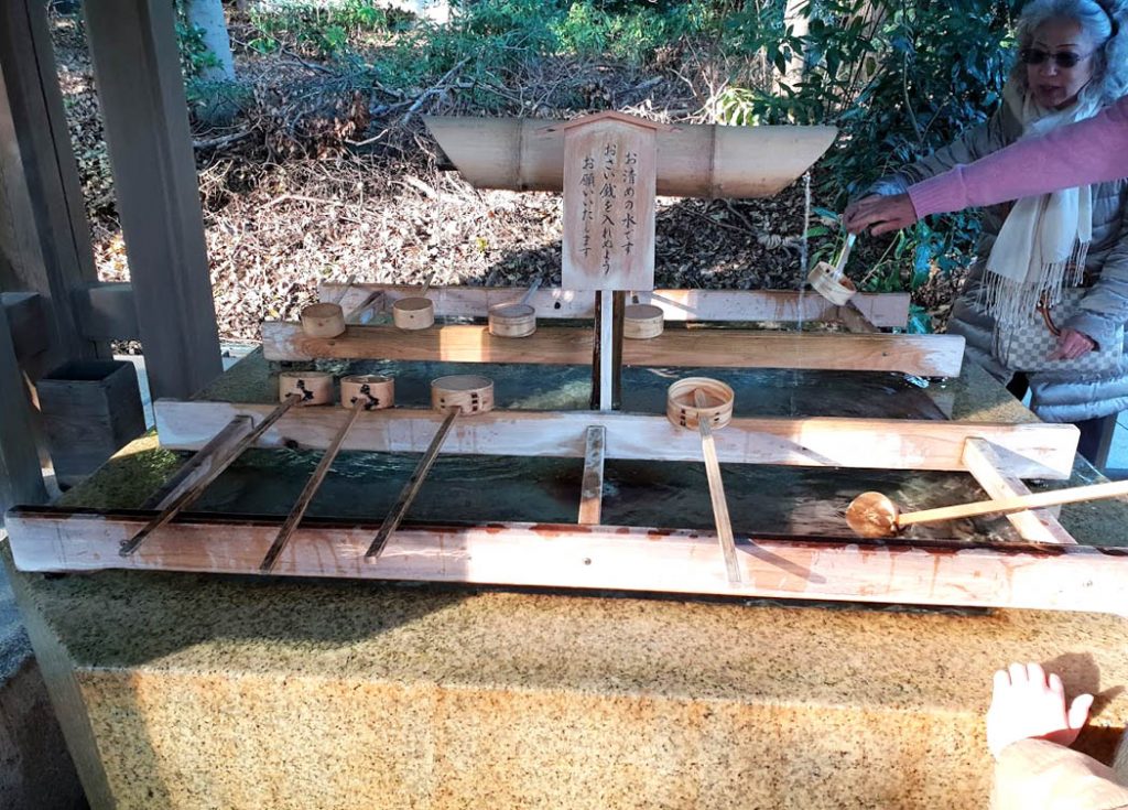 Image of a water founatin with timber struts and wooden ladels on the struts