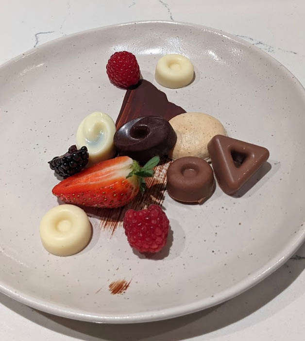 Image of a white plate with chocolates and berries