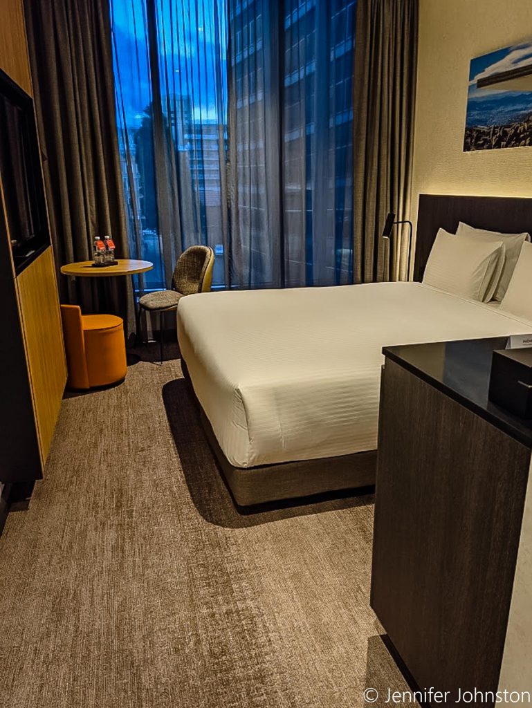 Image of a hotel room showing a large bed and room furnishings