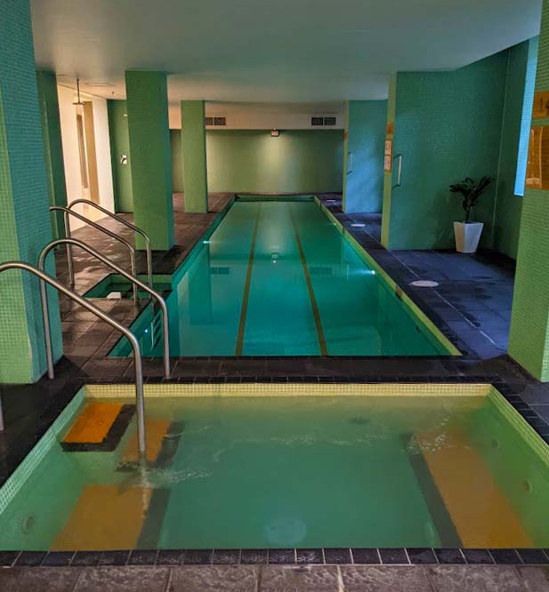 Image of an inside swimming pool with a small spa at one end and a ladder leading into both