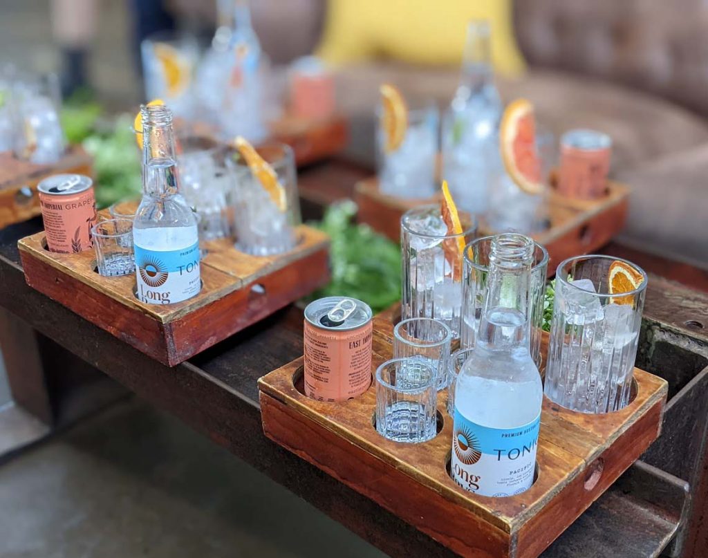 Image of a gin tasting tray with glasses filled with ice and small bottles next to it