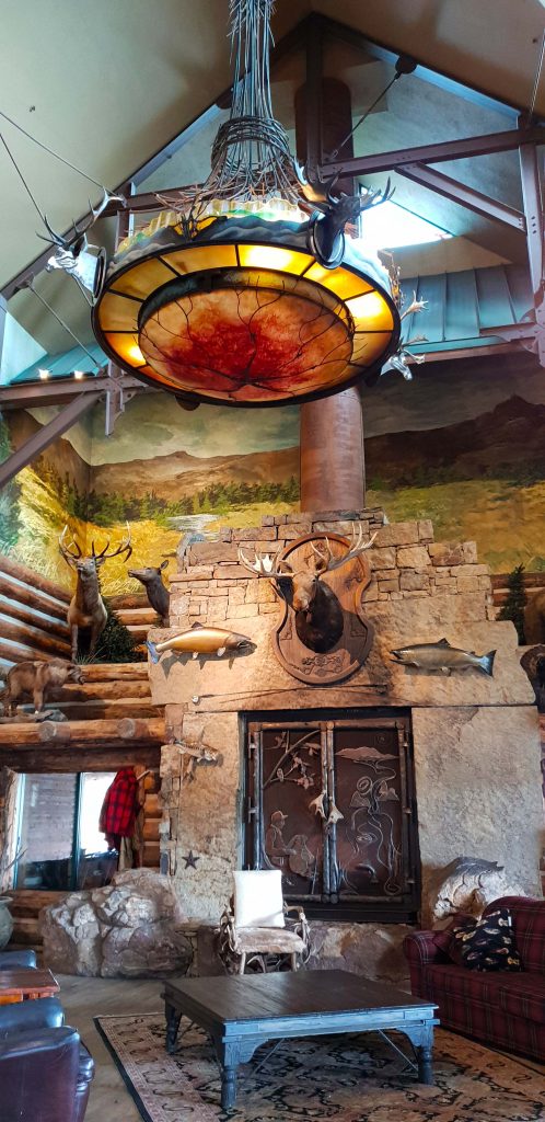 Image of an interior of a store that looks like a room in a hunters lodge with fish on the wall and a few moose head mounted on plaques