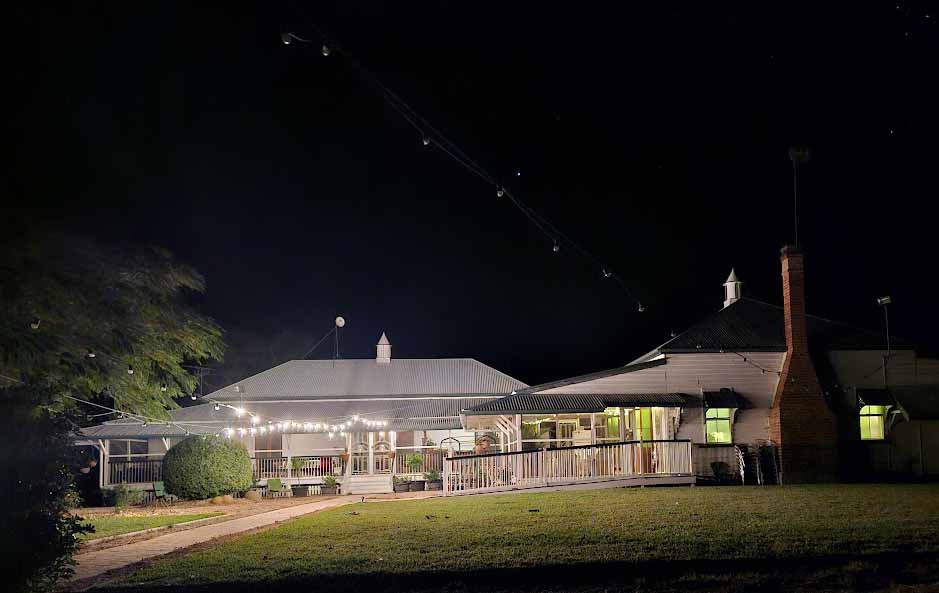 Image of an old Queensland home taken at night time with the dark night sky
